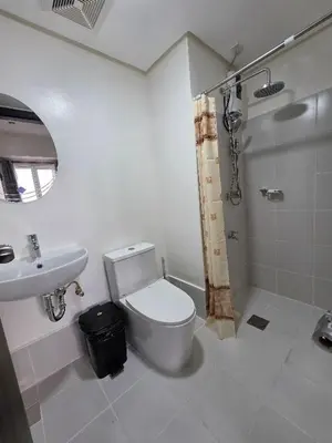 a bathroom with a toilet and a sink and a shower at 2 BR Penthouse with Sunset View in Manila