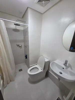 a white bathroom with a toilet and a sink at 2 BR Penthouse with Sunset View in Manila