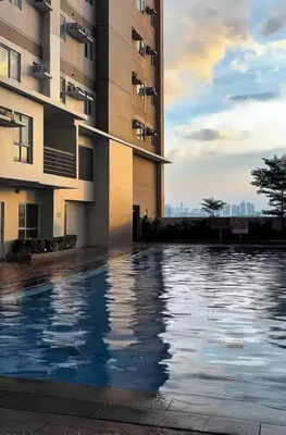 a swimming pool in front of a building at 2 BR Penthouse with Sunset View in Manila