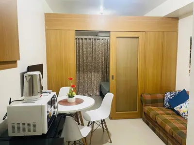 a living room with a couch and a table with a computer at Elegant Pasay City Apartment with Central Heating Shared Pool in Manila