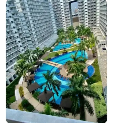 an aerial view of a resort swimming pool with palm trees at Elegant Pasay City Apartment with Central Heating Shared Pool in Manila