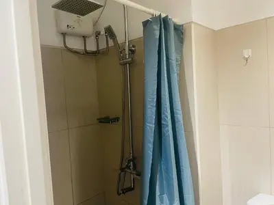 a shower with a blue shower curtain in a bathroom at Elegant Pasay City Apartment with Central Heating Shared Pool in Manila