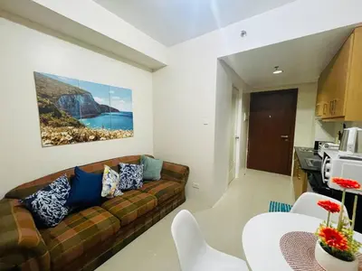 a living room with a couch and a table at Elegant Pasay City Apartment with Central Heating Shared Pool in Manila