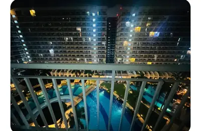 a view from the balcony of a building at night at Elegant Pasay City Apartment with Central Heating Shared Pool in Manila
