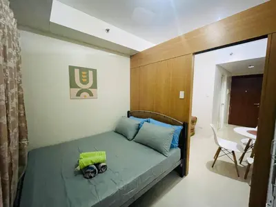 a bedroom with a bed and a table and a chair at Elegant Pasay City Apartment with Central Heating Shared Pool in Manila