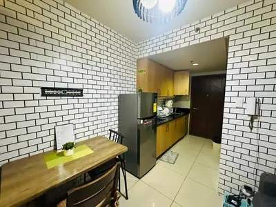 a kitchen with a stainless steel refrigerator and a table at Simple Pasay Getaway - Entire Apartment for Rent in Manila