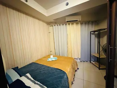 a bedroom with a bed in a room with curtains at Simple Pasay Getaway - Entire Apartment for Rent in Manila