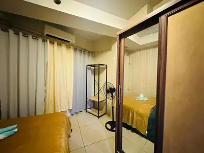 a room with a room with a bed and a mirror at Simple Pasay Getaway - Entire Apartment for Rent in Manila