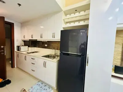 a kitchen with a black refrigerator and a sink at Charming 1-Bedroom Apartment in the Heart of Pasay City in Manila