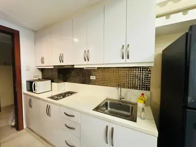 a kitchen with white cabinets and a sink at Charming 1-Bedroom Apartment in the Heart of Pasay City in Manila
