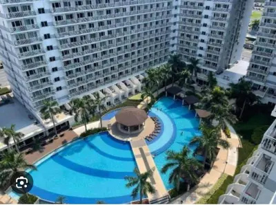 an overhead view of a large swimming pool in front of a building at Ultra Pasay City Apartment for Rent - Perfect for Short-Term Stay Front of MOA in Manila