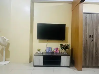 a living room with a flat screen tv on a wall at Timeless Pasay City Apartment for Rent in Manila