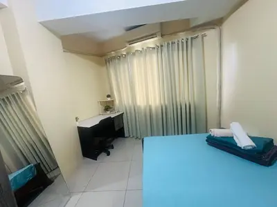 a room with a bed and a desk and a television at Timeless Pasay City Apartment for Rent in Manila
