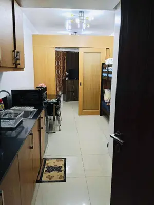 a kitchen with a counter and a dining room at Gentle Pasay City Apartment for Rent - Perfect Family Getaway Near Mall of Asia in Manila