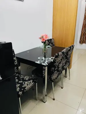 a dining room table with chairs and a vase of flowers at Gentle Pasay City Apartment for Rent - Perfect Family Getaway Near Mall of Asia in Manila