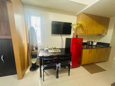 a kitchen with a table and a red refrigerator at Happy 1br Pasay Apartment for Rent -Peaceful Oasis in the City near Mall Of Asia in Manila