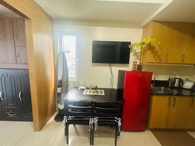 a kitchen with a table and a red refrigerator at Happy 1br Pasay Apartment for Rent -Peaceful Oasis in the City near Mall Of Asia in Manila