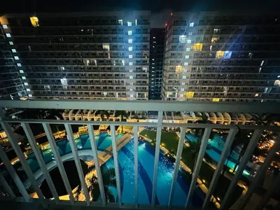 a view from the balcony of a building at night at Happy 1br Pasay Apartment for Rent -Peaceful Oasis in the City near Mall Of Asia in Manila