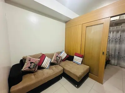 a living room with a couch with pillows on it at Happy 1br Pasay Apartment for Rent -Peaceful Oasis in the City near Mall Of Asia in Manila