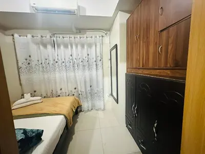 a small bedroom with a bed and a shower at Happy 1br Pasay Apartment for Rent -Peaceful Oasis in the City near Mall Of Asia in Manila
