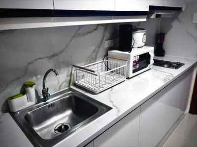 a kitchen counter with a sink and a microwave at Yare Pasay City Apartment for Rent Perfect for Stay front of Mall of Asia in Manila