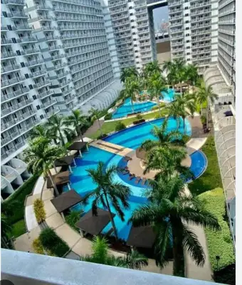 an aerial view of a resort swimming pool with palm trees at Yare Pasay City Apartment for Rent Perfect for Stay front of Mall of Asia in Manila