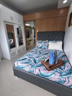 a bedroom with a large bed with a wooden headboard at idyllic Apartment for Rent - Perfect for Short-Term Stay Front of Mall of Asia in Manila