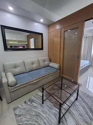 a living room with a couch and a mirror at idyllic Apartment for Rent - Perfect for Short-Term Stay Front of Mall of Asia in Manila