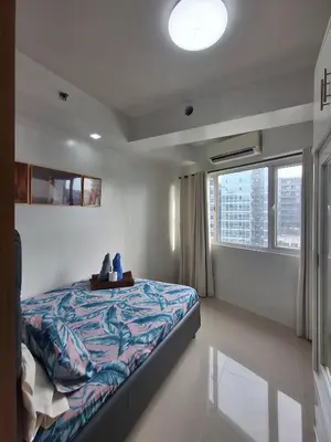 a bedroom with a bed and a large window at idyllic Apartment for Rent - Perfect for Short-Term Stay Front of Mall of Asia in Manila