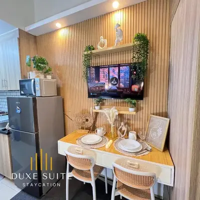 a kitchen with a table with chairs and a refrigerator at Staycation in RLX in Manila