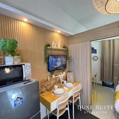 a dining room with a table and a microwave at Staycation in RLX in Manila