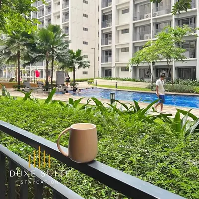 a coffee cup sitting on a fence near a pool at Staycation in RLX in Manila