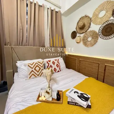 a bed with a tray with some items on it at Staycation in RLX in Manila