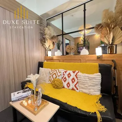 a couch with a yellow blanket and a table at Staycation in RLX in Manila