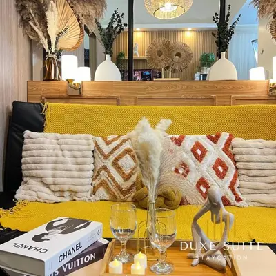 a table with two wine glasses on a yellow couch at Staycation in RLX in Manila
