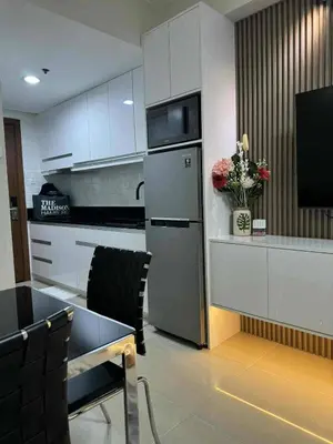 a kitchen with white cabinets and a stainless steel refrigerator at Chic Retreat in Pasay City - Scandinavian with Balcony facing Mall Of Asia in Manila