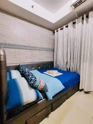 a bed with pillows on it in a room at Peaceful Pasay Oasis - Entire Apartment for Rent in Manila