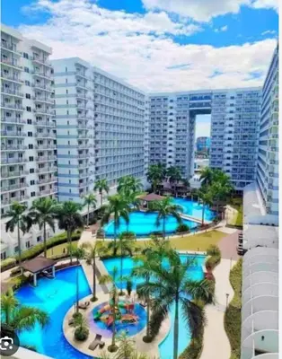 an aerial view of a resort pool with palm trees at Xenial Pasay City Apartment for Rent - Entire House Front of Mall of Asia in Manila