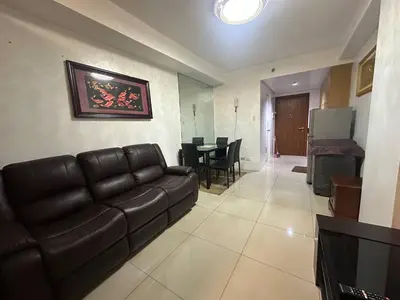 a living room with a leather couch and a table at Dainty Pasay City Apartment for Rent - Entire House Front of Mall of Asia in Manila