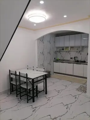 a dining room with a table and a kitchen at Navio Transient House in Cabuyao