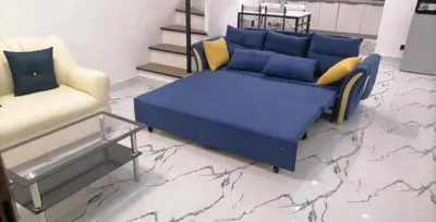 a living room with a blue bed and a chair at Navio Transient House in Cabuyao