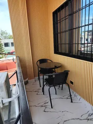 a patio with two chairs and a table on a balcony at Navio Transient House in Cabuyao