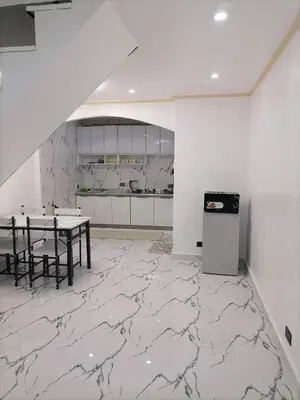a kitchen with marble flooring and a table in a room at Navio Transient House in Cabuyao