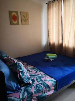 a bed with a blue sheets and pillows on it at Fancy Pasay City Apartment for Rent - Mall of Asia Nearby front of Mall Of Asia in Manila