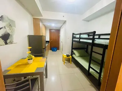 a room with two bunk beds and a table at Joyful Pasay Getaway Staycation Condo Near MOA and IKEA near Mall of Asia in Manila
