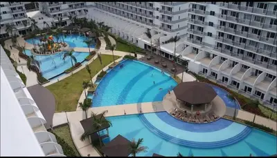an overhead view of a large swimming pool in a resort at Joyful Pasay Getaway Staycation Condo Near MOA and IKEA near Mall of Asia in Manila