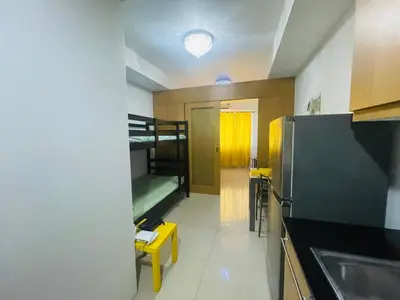 a kitchen with a bunk bed and a refrigerator at Joyful Pasay Getaway Staycation Condo Near MOA and IKEA near Mall of Asia in Manila