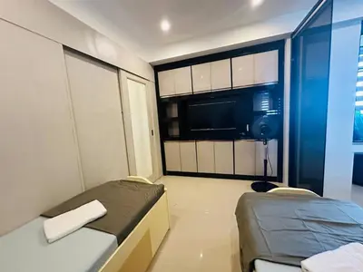 a small room with two beds and a window at Quaint 2BR Connected Apartment in Pasay City - Perfect for Families front of MOA in Manila