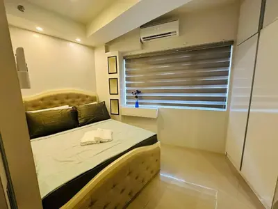 a small bedroom with a bed and a tub at Quaint 2BR Connected Apartment in Pasay City - Perfect for Families front of MOA in Manila