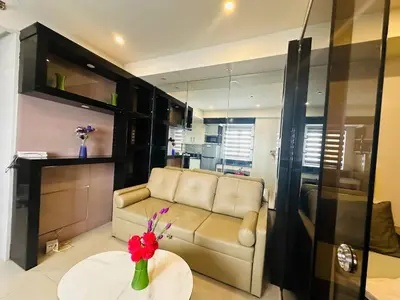 a living room with a couch and a table at Quaint 2BR Connected Apartment in Pasay City - Perfect for Families front of MOA in Manila